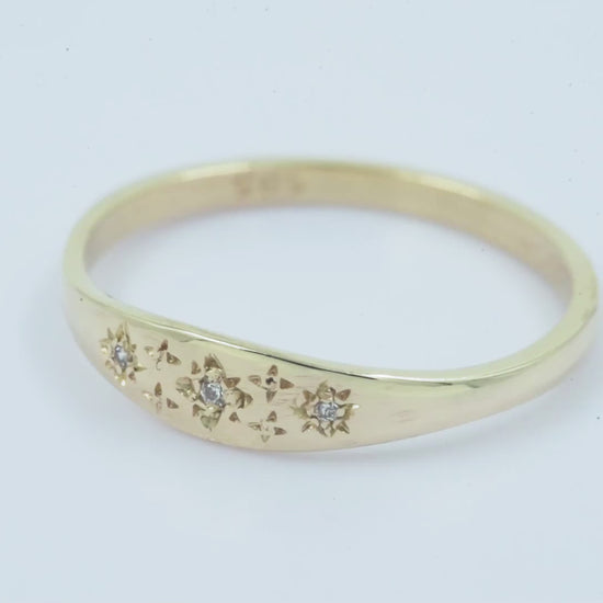 Handcrafted Starburst Ring in 14k gold, embellished with cubic zirconia stones and featuring four engraved stars.