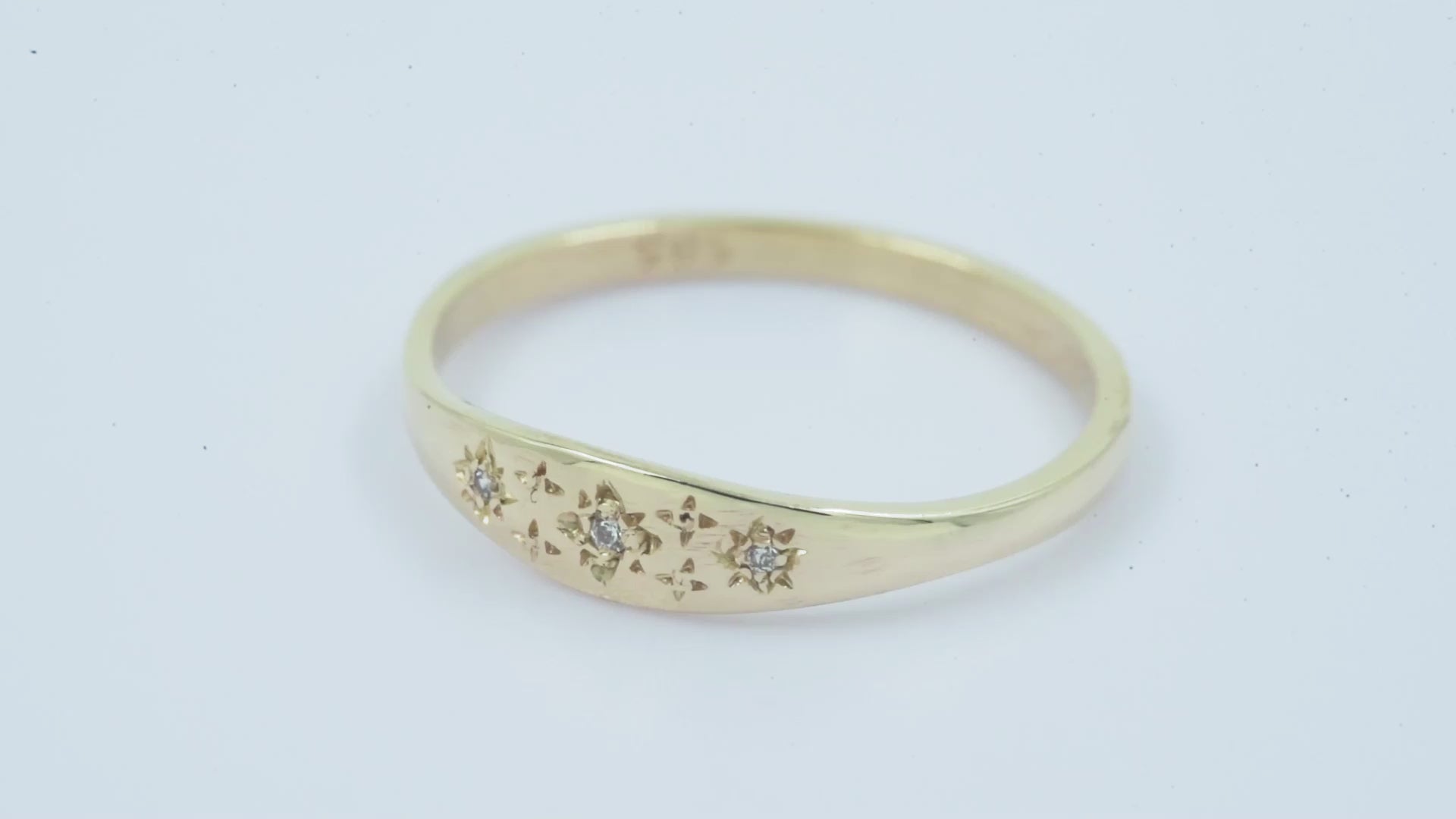 Handcrafted Starburst Ring in 14k gold, embellished with cubic zirconia stones and featuring four engraved stars.