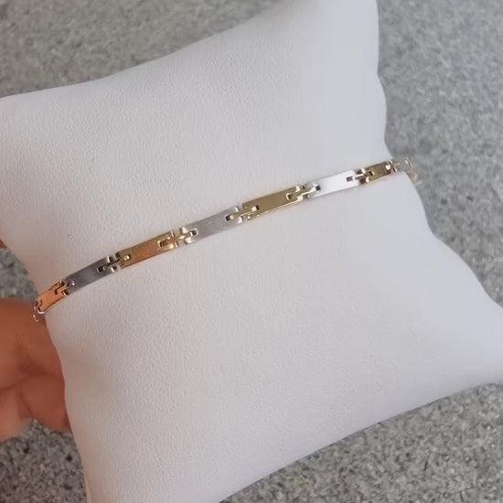 a sleek men's bracelet made of polished metal, yellow-white gold. It features rectangular links connected by smaller rounded connectors, creating a clean, modern design with subtle detailing.