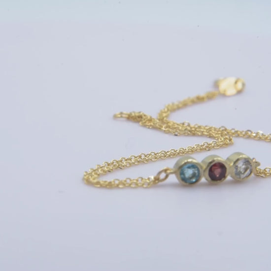 Handmade birthstone bracelet featuring three stones set in 14k gold, complemented by a double chain design for women.