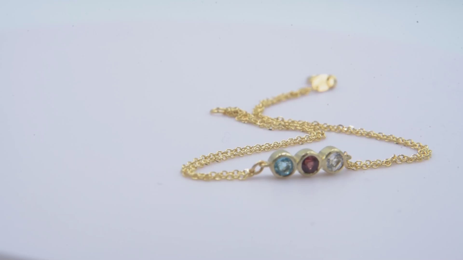 Handmade birthstone bracelet featuring three stones set in 14k gold, complemented by a double chain design for women.