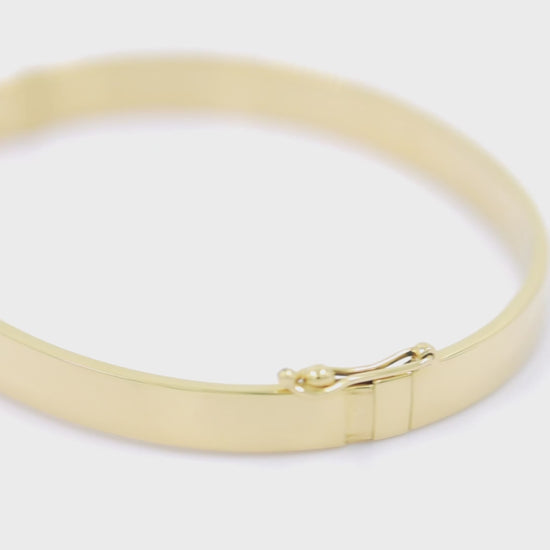 A 6.00mm hinged bangle bracelet crafted in 14k gold for women.