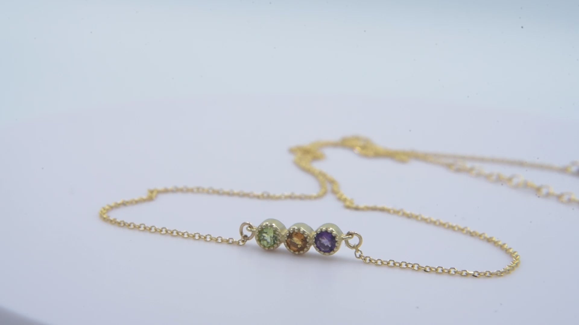 Handcrafted birthstone necklace in 14k gold, featuring three stones in a prong setting.