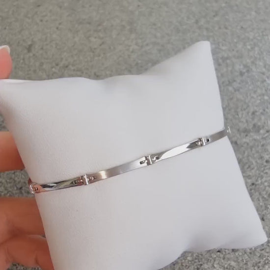 A sleek men's bracelet made of polished white gold. It features rectangular links connected by smaller rounded connectors, creating a clean, modern design with subtle detailing.