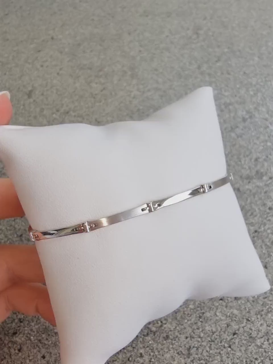 A sleek men's bracelet made of polished white gold. It features rectangular links connected by smaller rounded connectors, creating a clean, modern design with subtle detailing.