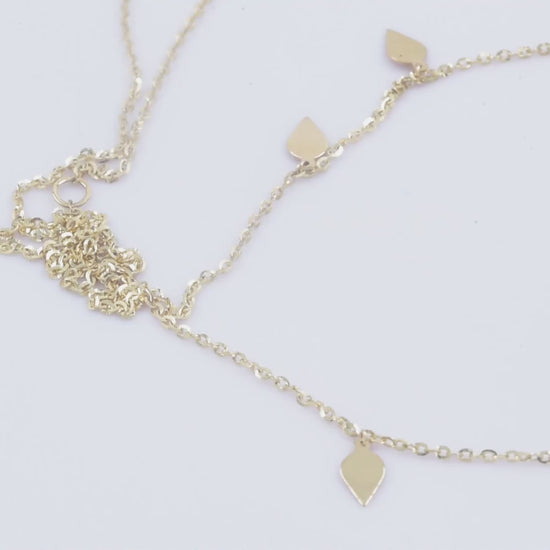 A station necklace featuring seven leaves crafted in 14k yellow gold for women.