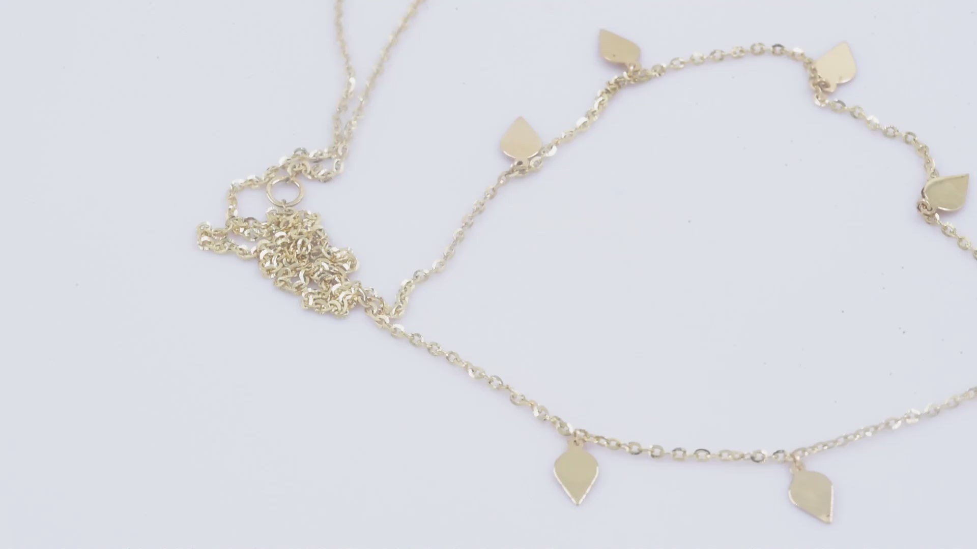 A station necklace featuring seven leaves crafted in 14k yellow gold for women.