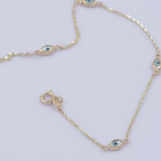 A women's Evil Eye bracelet featuring four charms crafted in 14k solid gold.