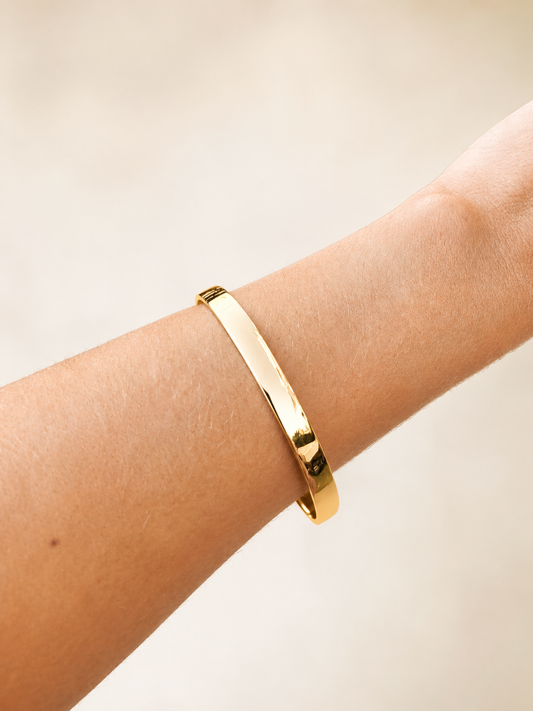 14k gold bangle bracelet worn on a wrist