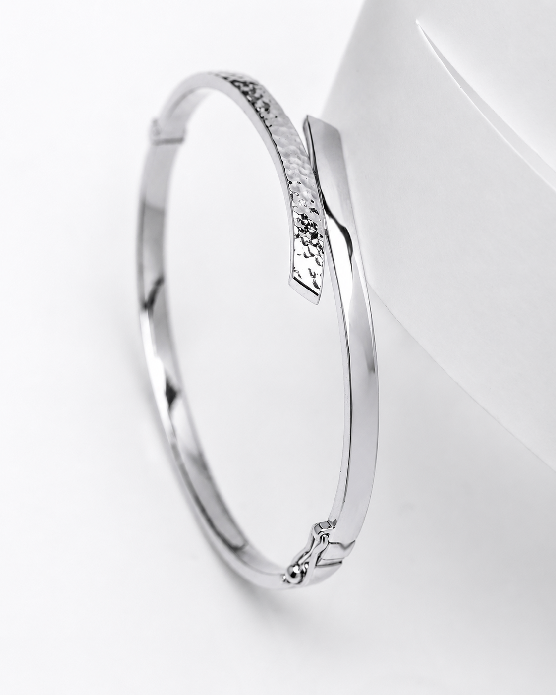 A 14k white gold bypass bangle bracelet with a dual-finished top face, smooth and polished, displayed on a white surface.