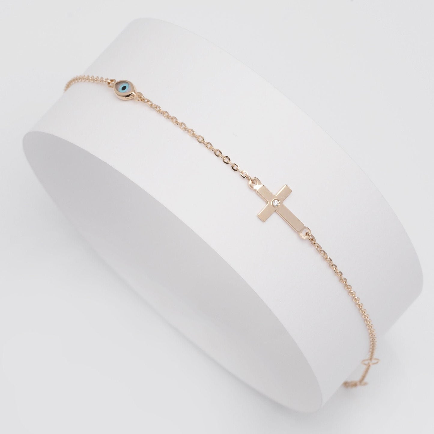 diamond cross and evil eye bracelet in 14k yellow gold