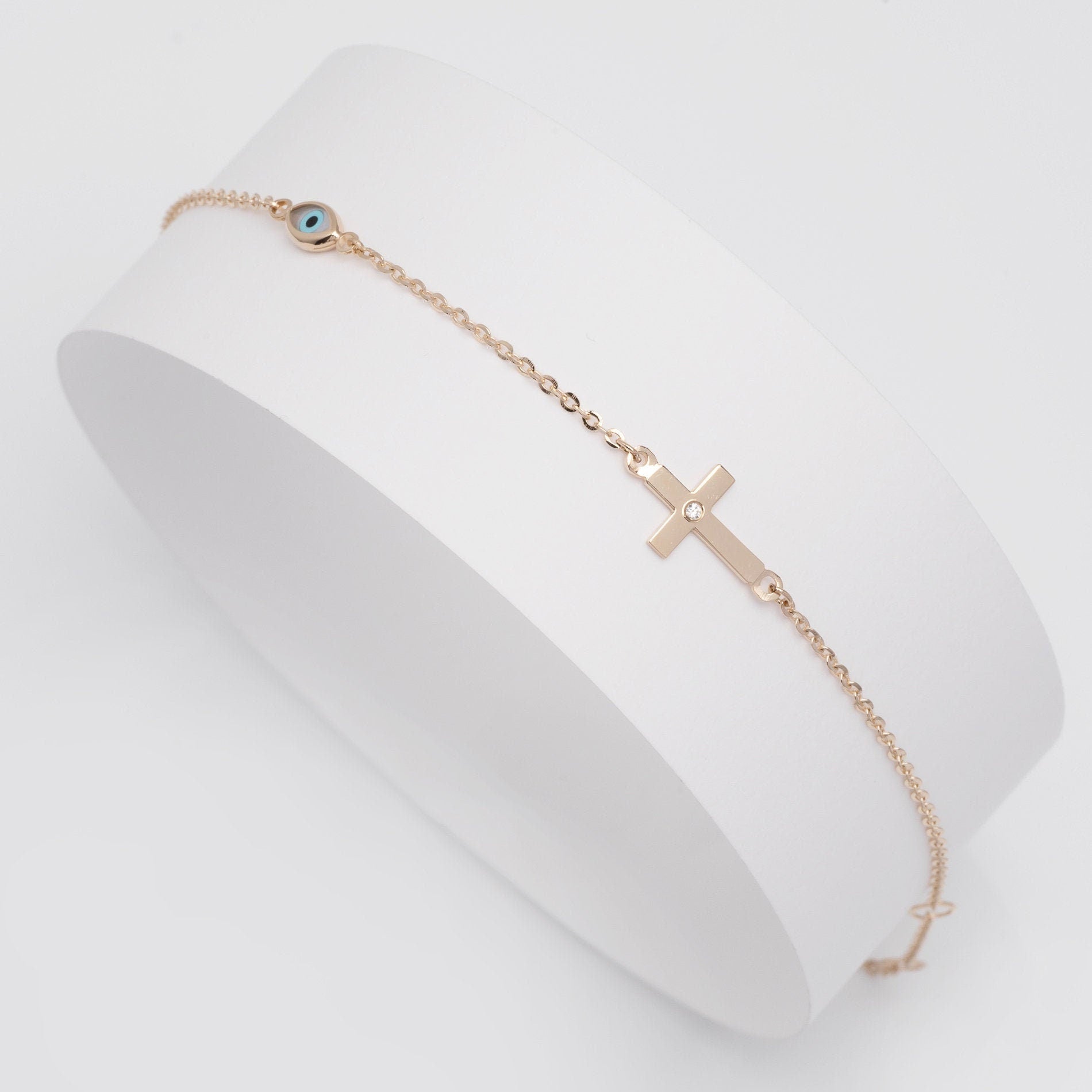 diamond cross and evil eye bracelet in 14k yellow gold