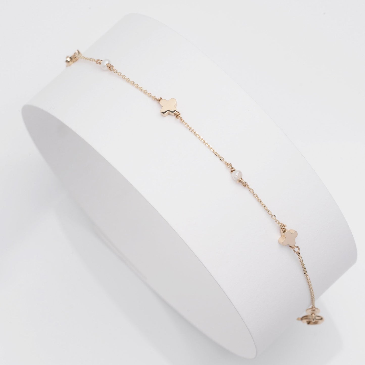 A station bracelet featuring clover motifs and delicate freshwater pearls set in 14k solid gold.