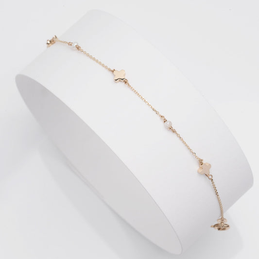 A station bracelet featuring clover motifs and delicate freshwater pearls set in 14k solid gold.