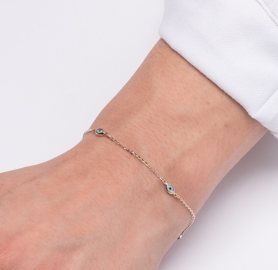 A women's Evil Eye bracelet featuring four charms crafted in 14k solid gold.