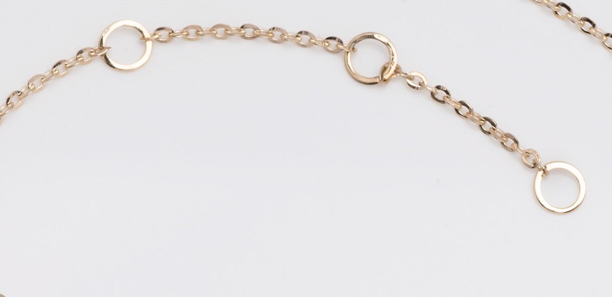 a  bracelet extender with three links in 14k yellow gold