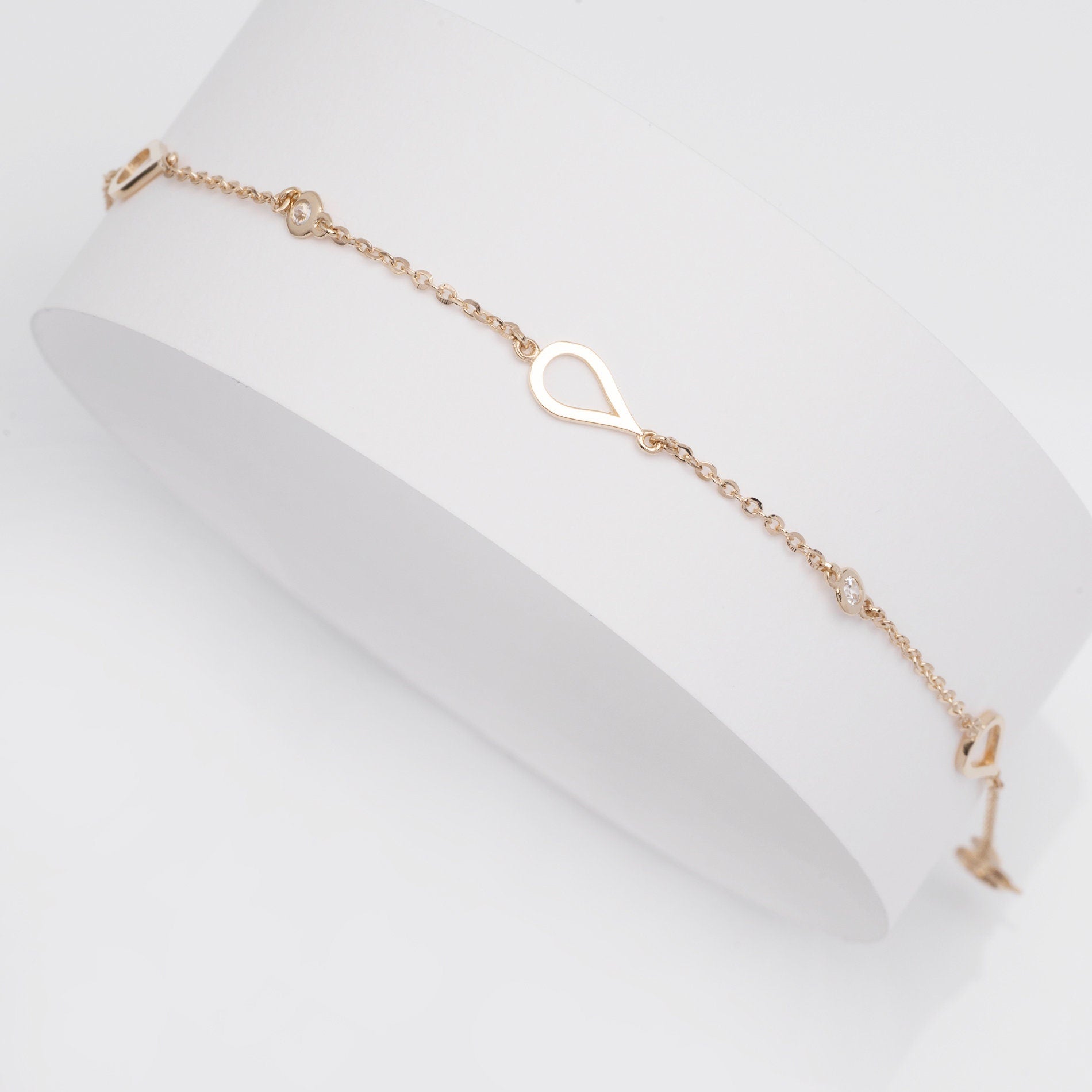 A 14k solid gold bracelet featuring droplets and cubic zirconia stones set in 14k gold.