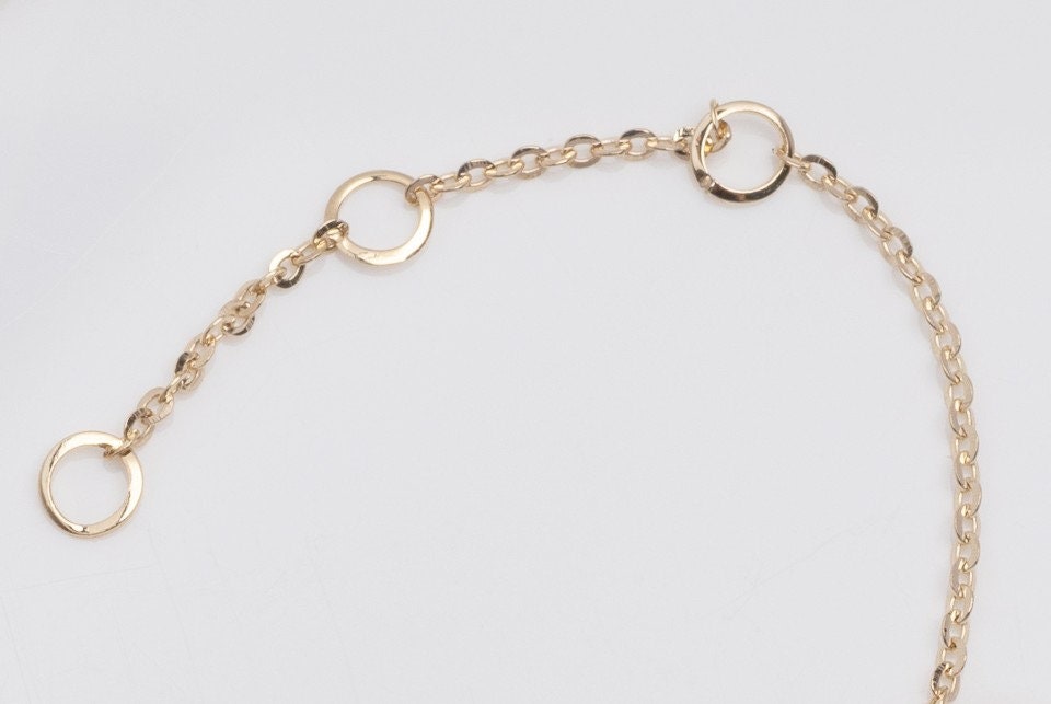 A bracelet extender featuring three links in 14k gold.