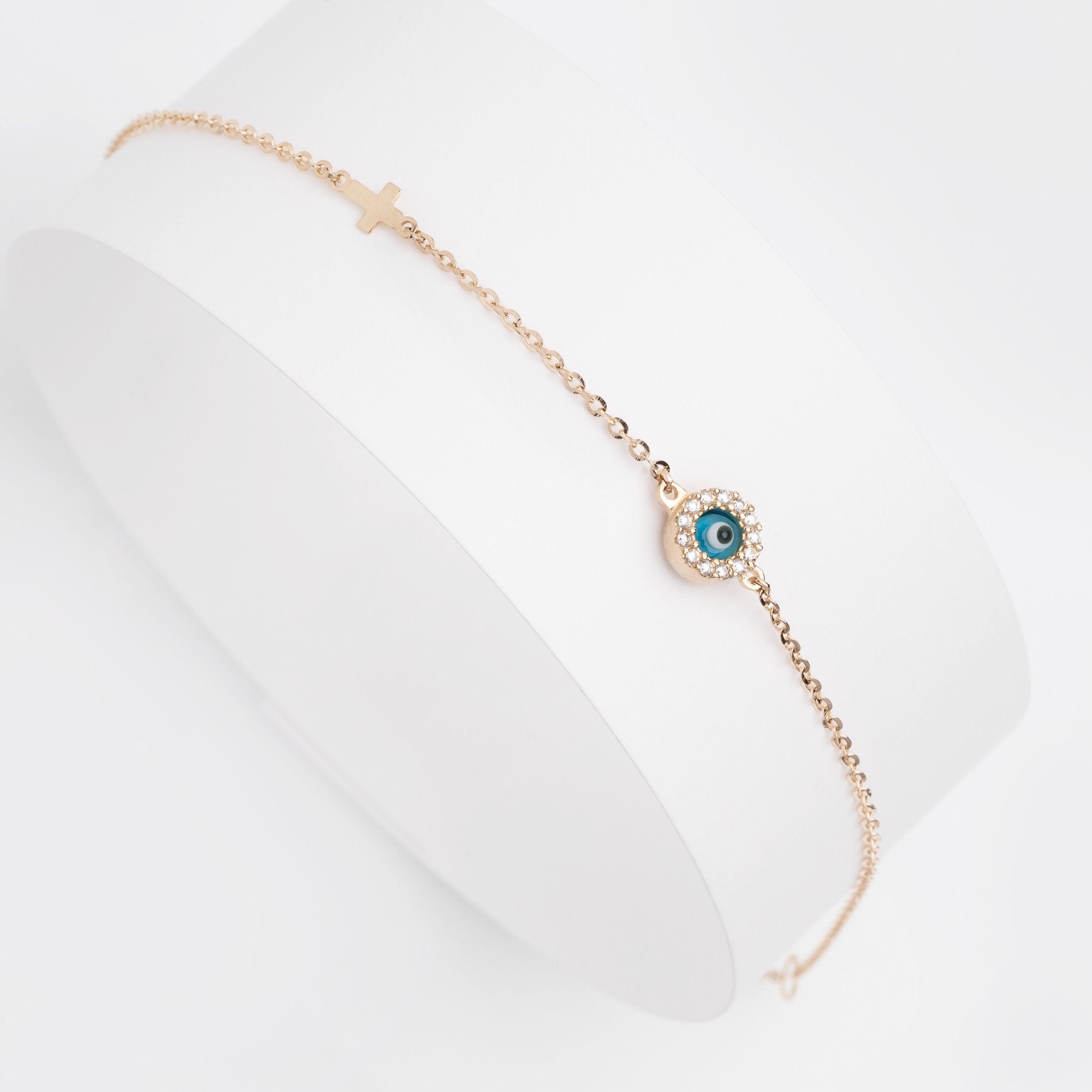 round evil eye bracelet with mourano glass and cubic zirconia stones and a small cross