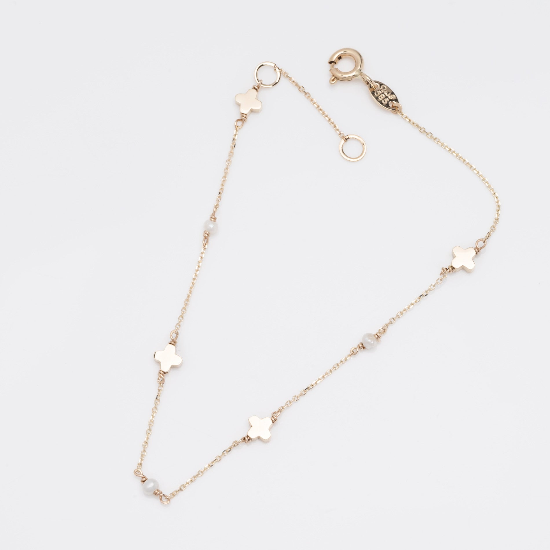 A station bracelet featuring clover motifs and delicate freshwater pearls set in 14k solid gold.