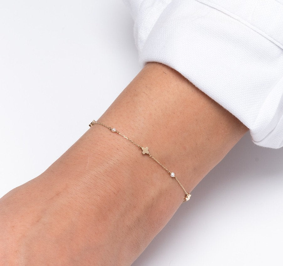 A station bracelet featuring clover motifs and delicate freshwater pearls set in 14k solid gold.