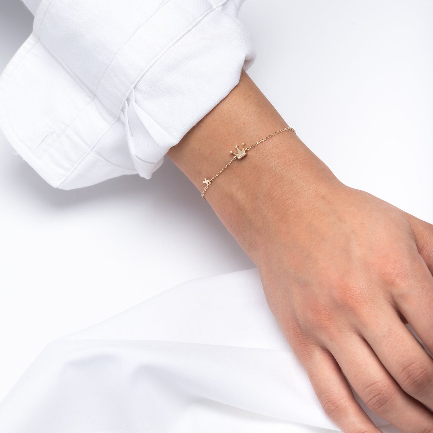 Crown and Cross Charm Bracelet in 14k Gold for Women, Modeled by a Professional