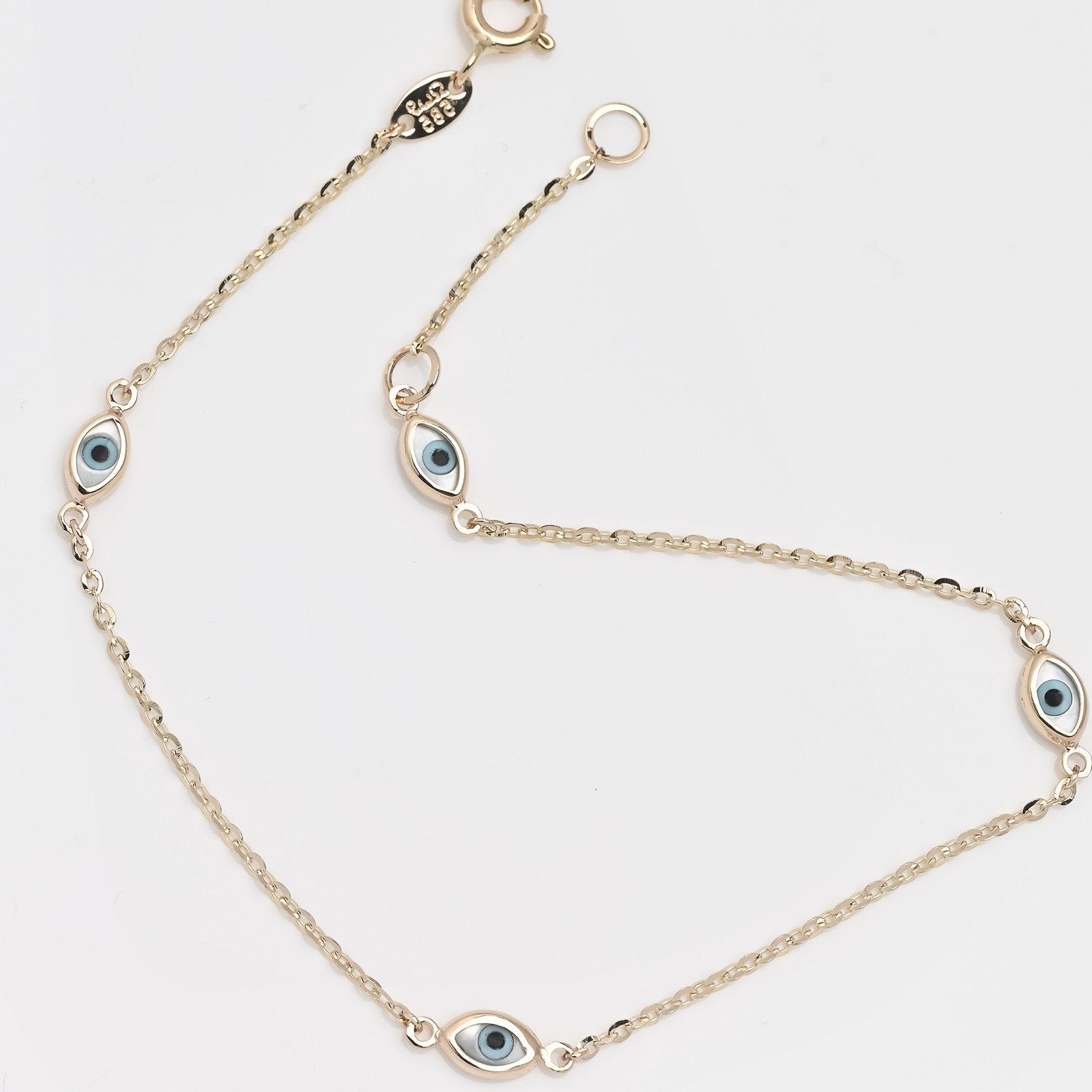 A women's Evil Eye bracelet featuring four charms crafted in 14k solid gold.