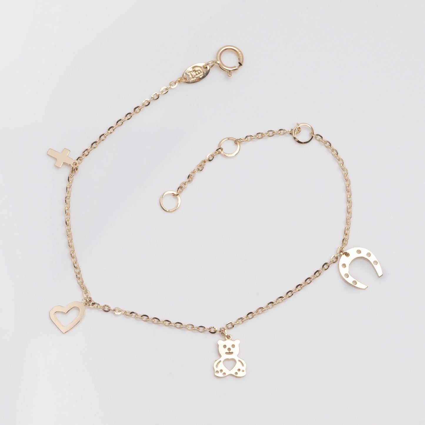 14k gold bracelet with hangginh charms, cross, heart, bear, horseshoe