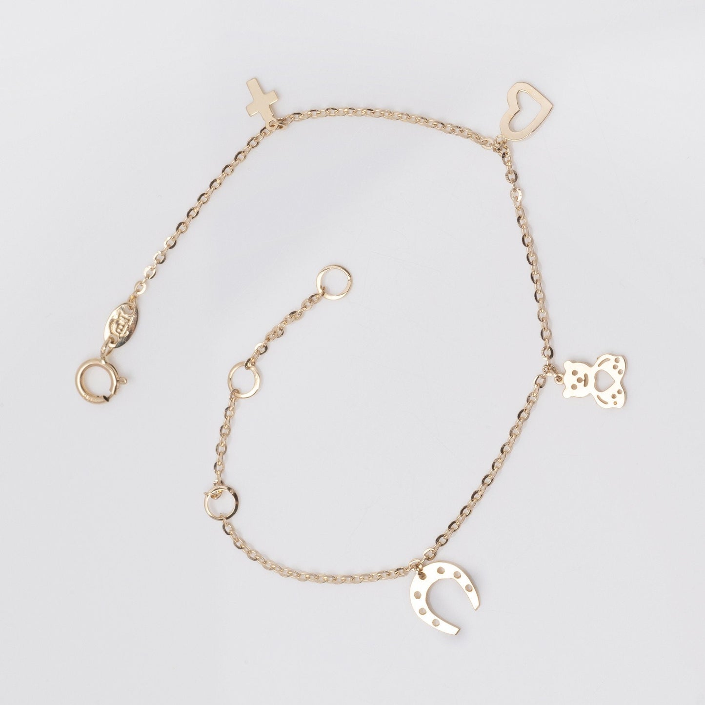 14k gold bracelet with hangginh charms, cross, heart, bear, horseshoe 