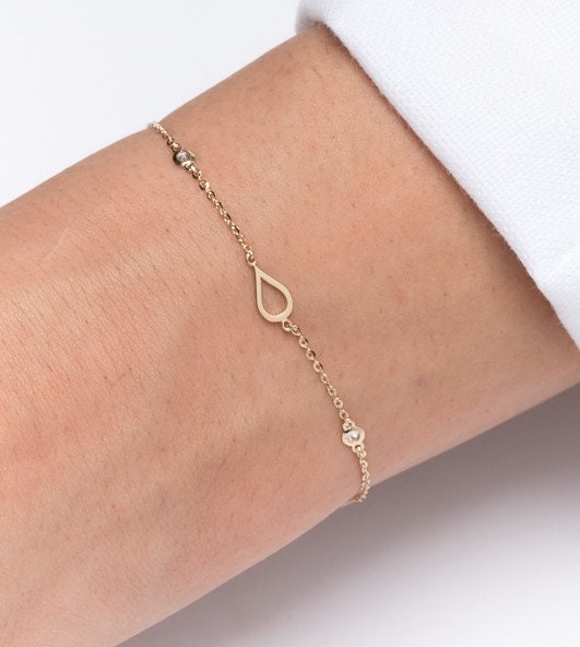 A 14k solid gold bracelet featuring droplets and cubic zirconia stones set in 14k gold.