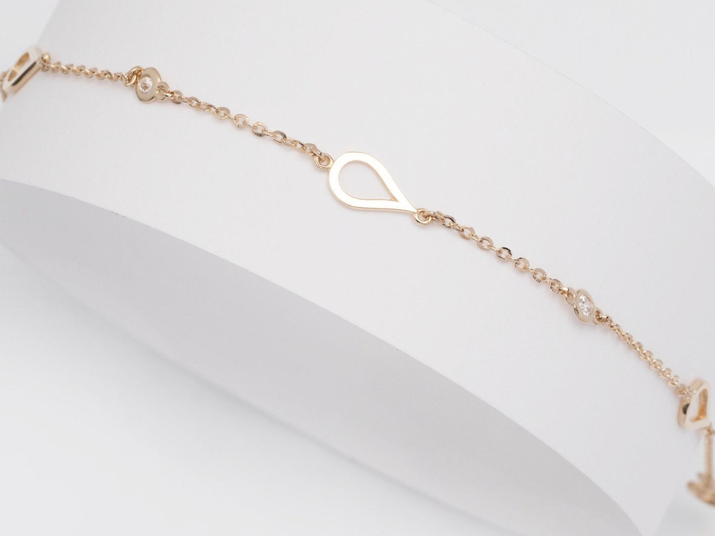 A 14k solid gold bracelet featuring droplets and cubic zirconia stones set in 14k gold.