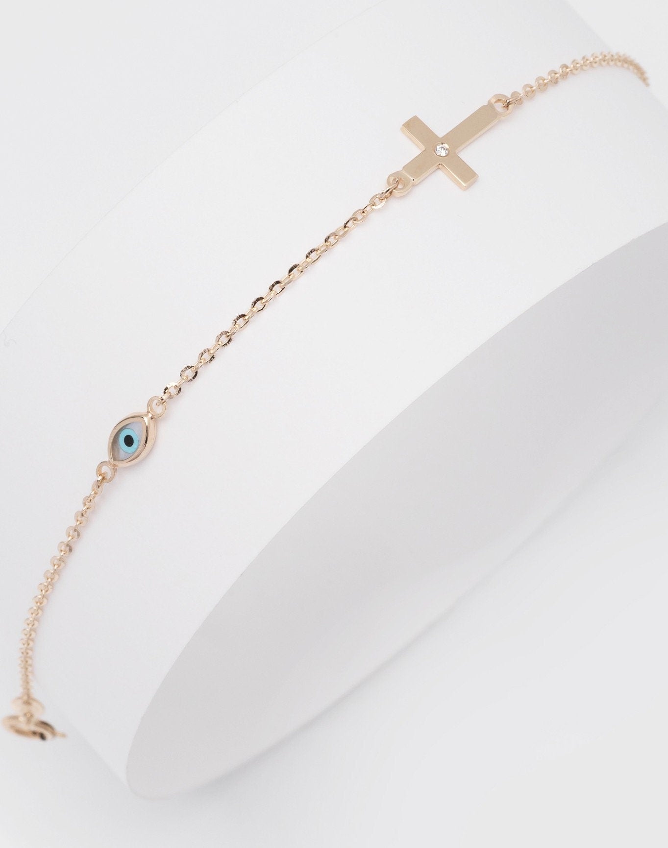 diamond cross and evil eye bracelet in 14k yellow gold