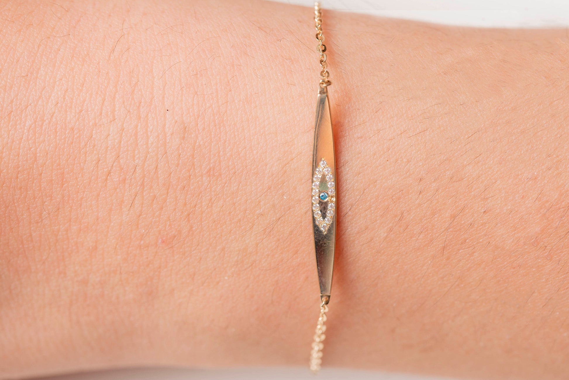 evil eye ID bracelet in 14k yellow gold worn by a model 