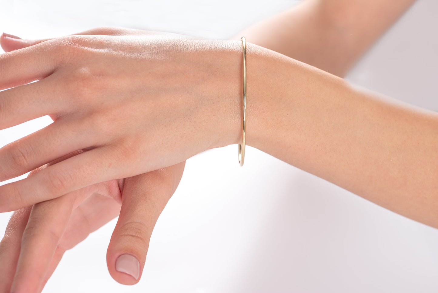 slip on 14k solid gold bangle bracelet for women worn by a model