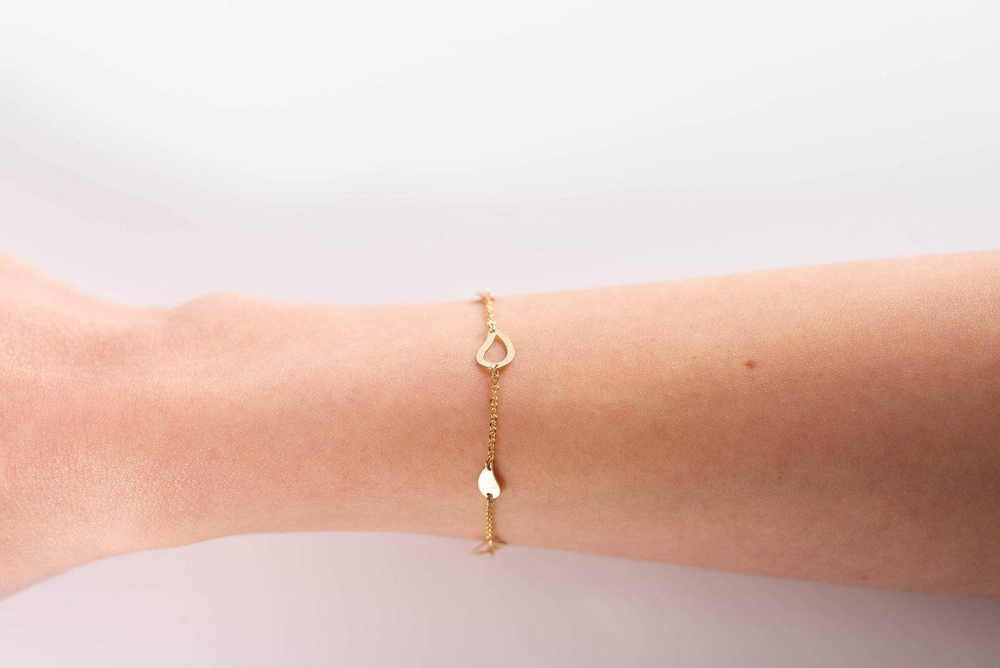 chain bracelet with leaves in 14k sold gold worn by a model 