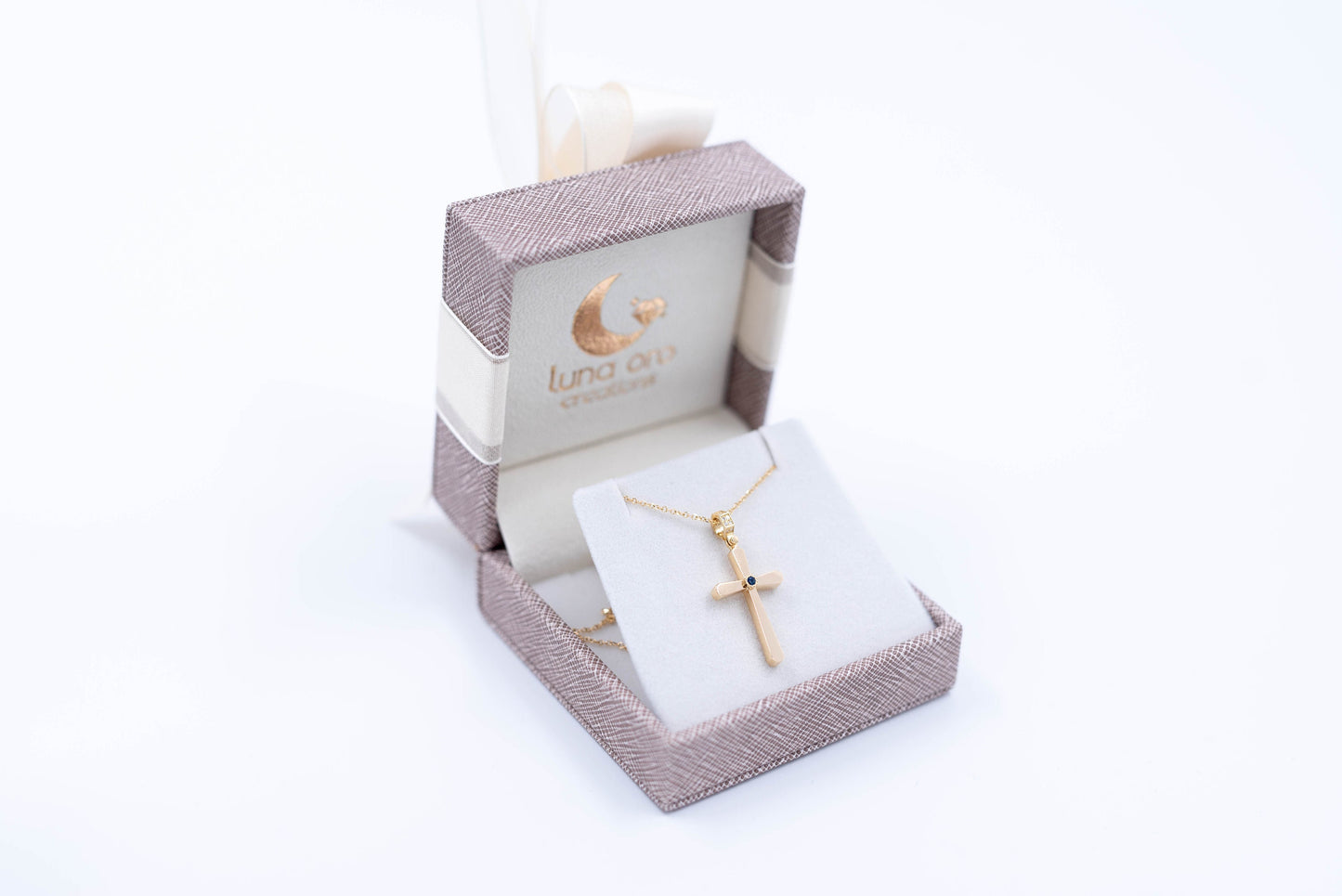 Leather jewelry box featuring a 14k gold cross, crafted by Luna Oro Creations