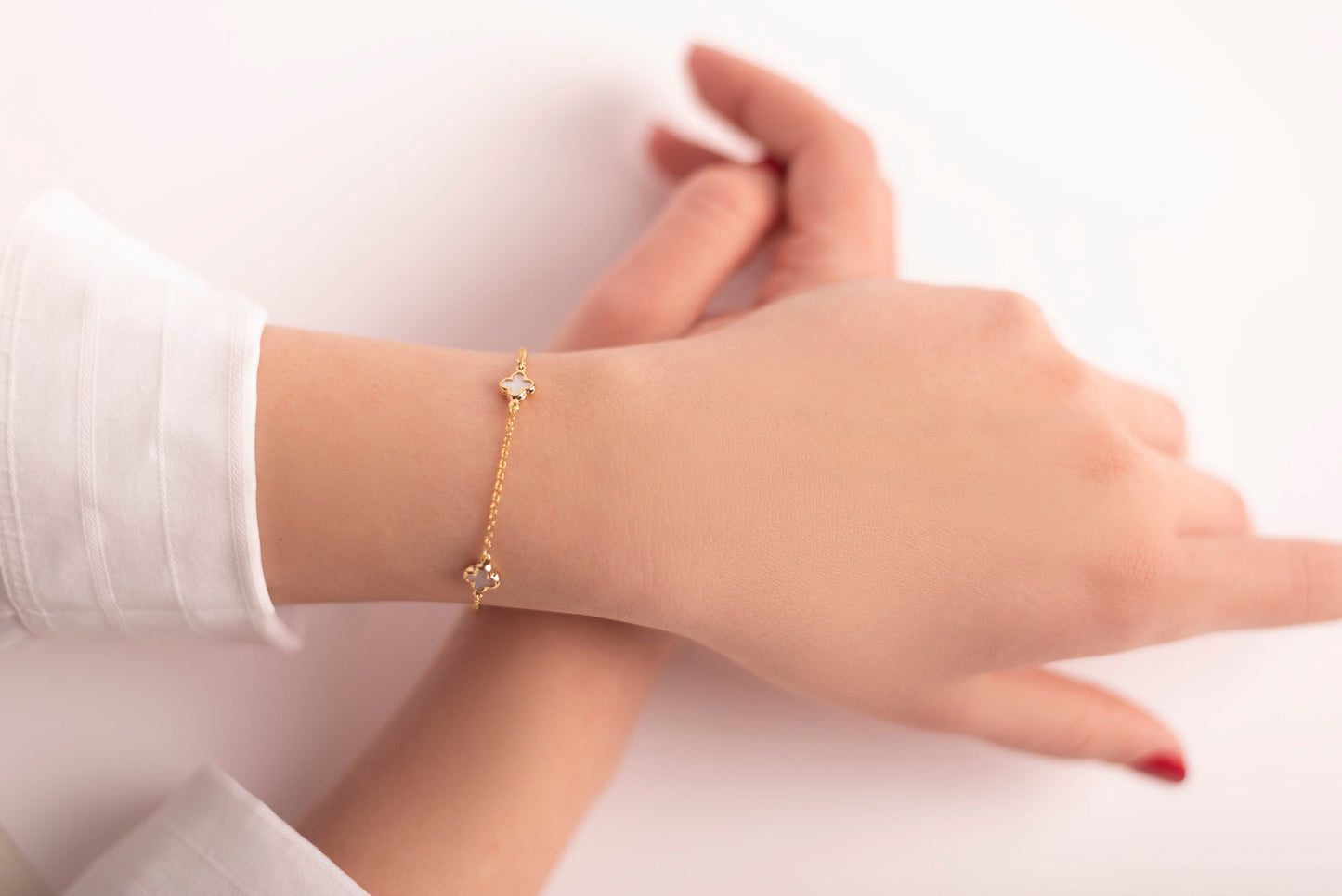 four leaf clover bracelet with 3 charms in 14k gold worn by a model 