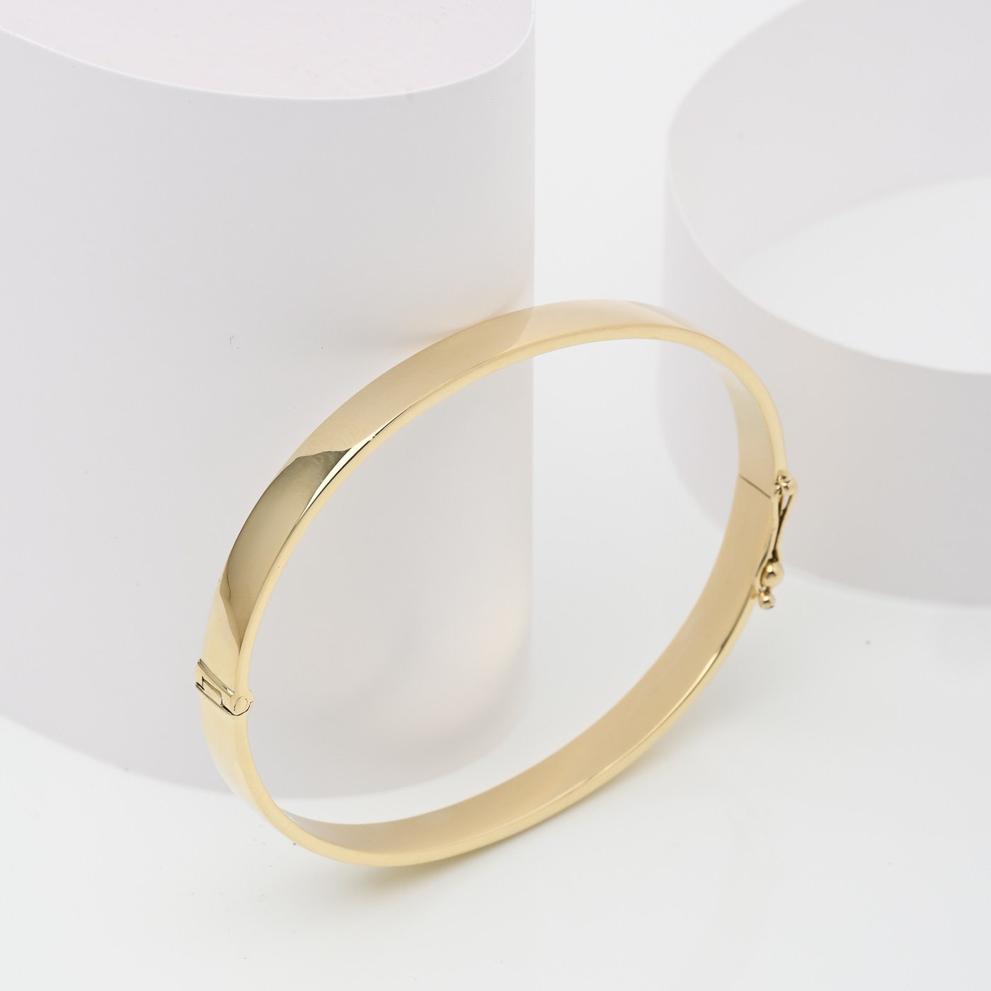 A 6.00mm hinged bangle bracelet crafted in 14k gold for women.