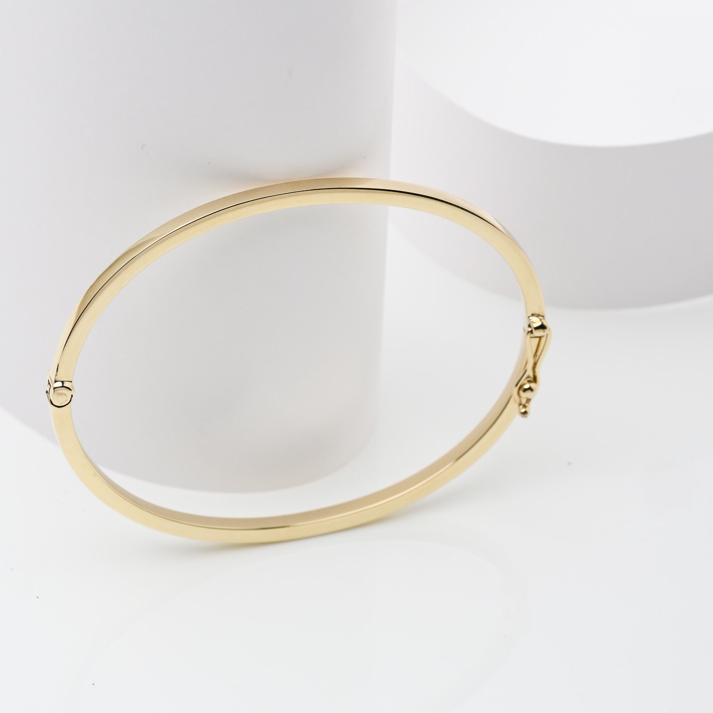 A 3.40mm hinged bangle bracelet in 14k gold, is an elegant choice for women.