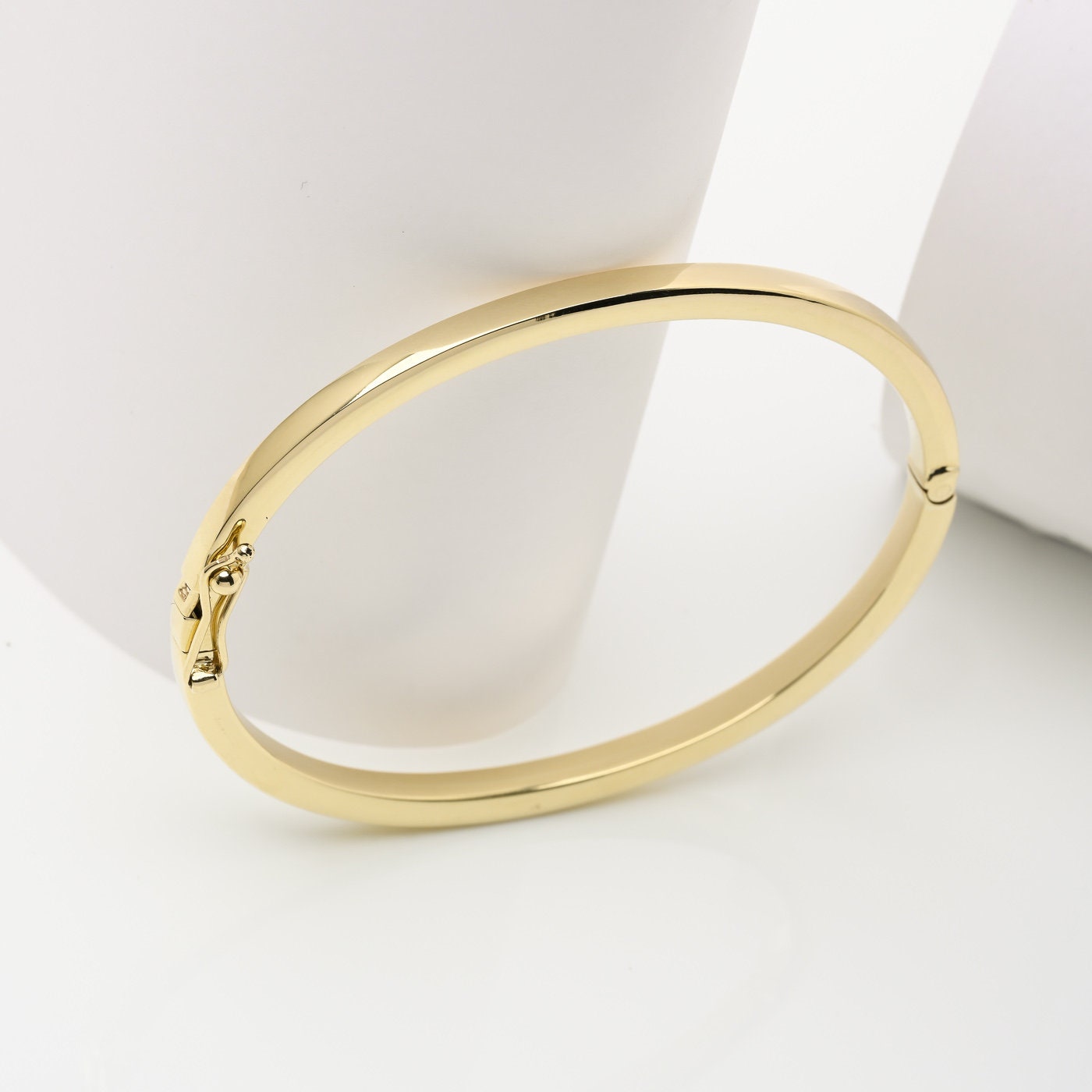 A 3.40mm hinged bangle bracelet in 14k gold, is an elegant choice for women.