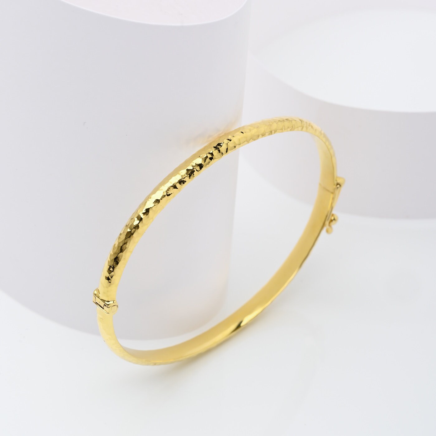 A 4.20mm hammered bangle bracelet in 14k gold, designed for women to adorn their wrist.