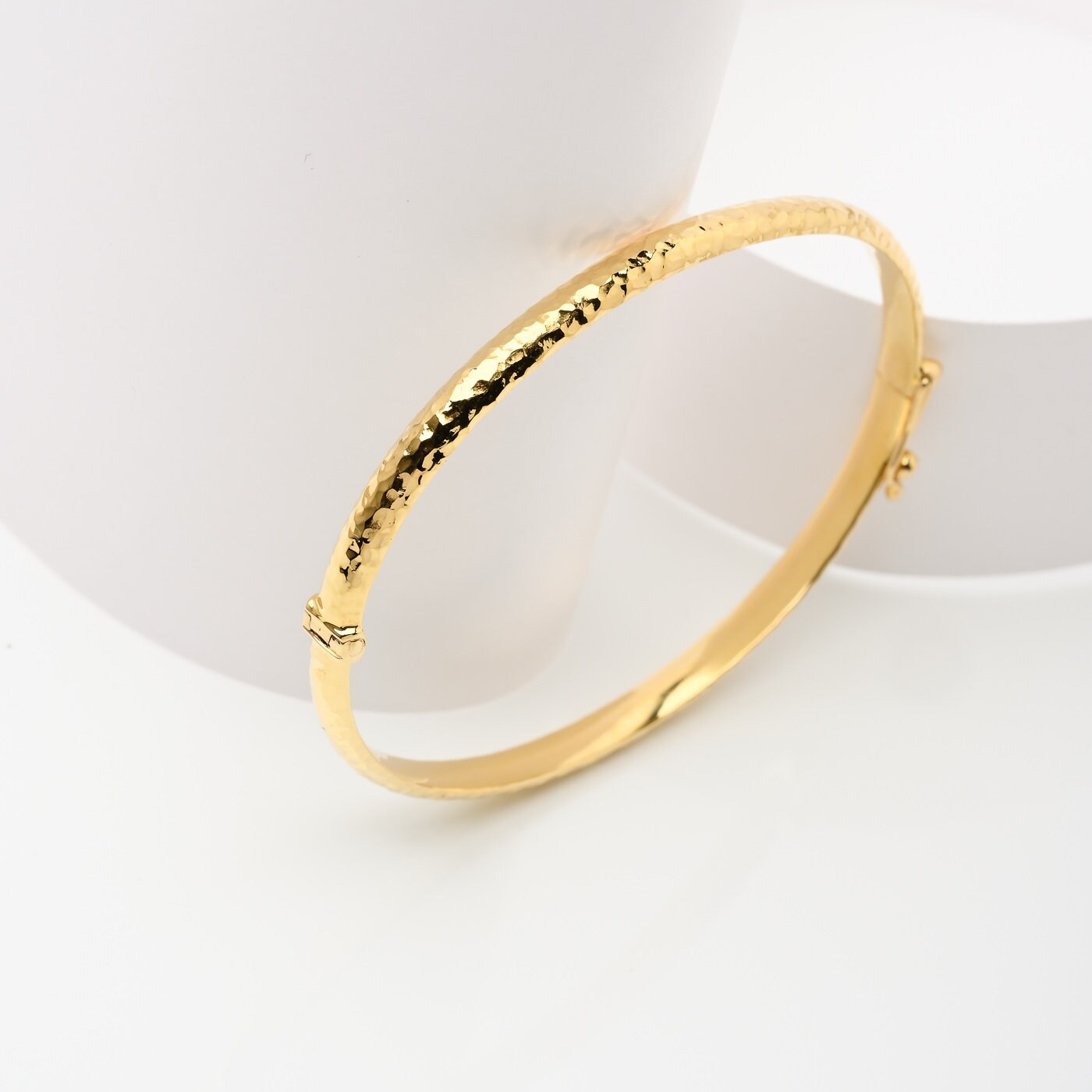 A 4.20mm hammered bangle bracelet in 14k gold, designed for women to adorn their wrist.