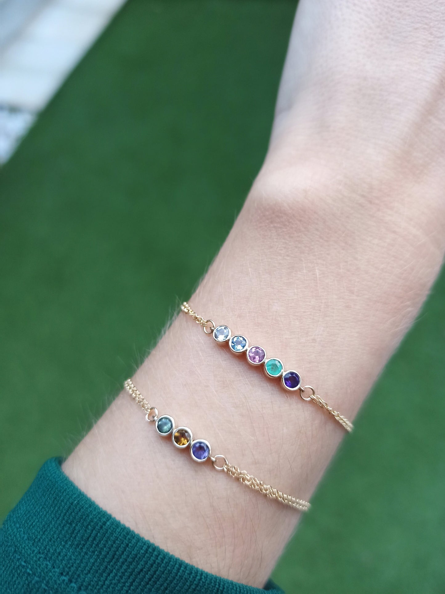 A birthstone bracelet featuring either five or three stones, set in 14k gold with a double chain design.