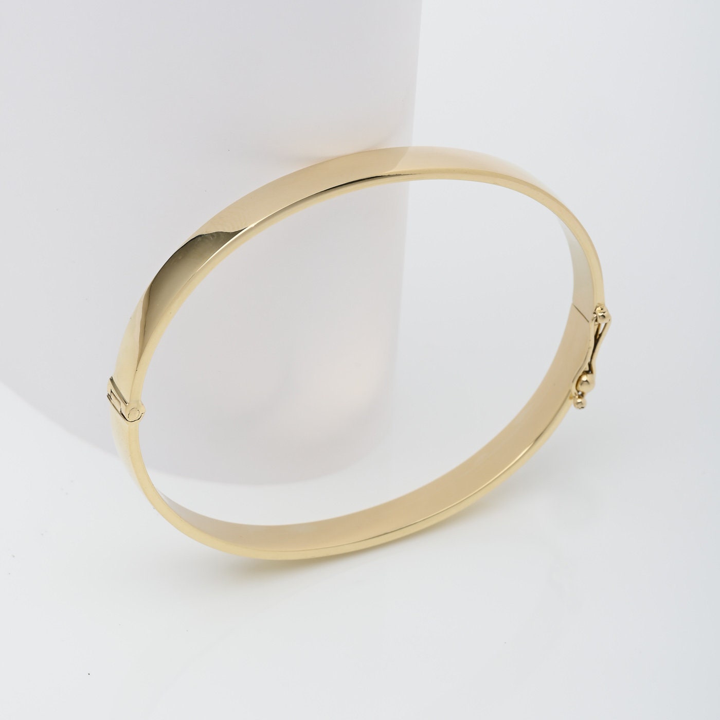 A 6.00mm hinged bangle bracelet crafted in 14k gold for women.