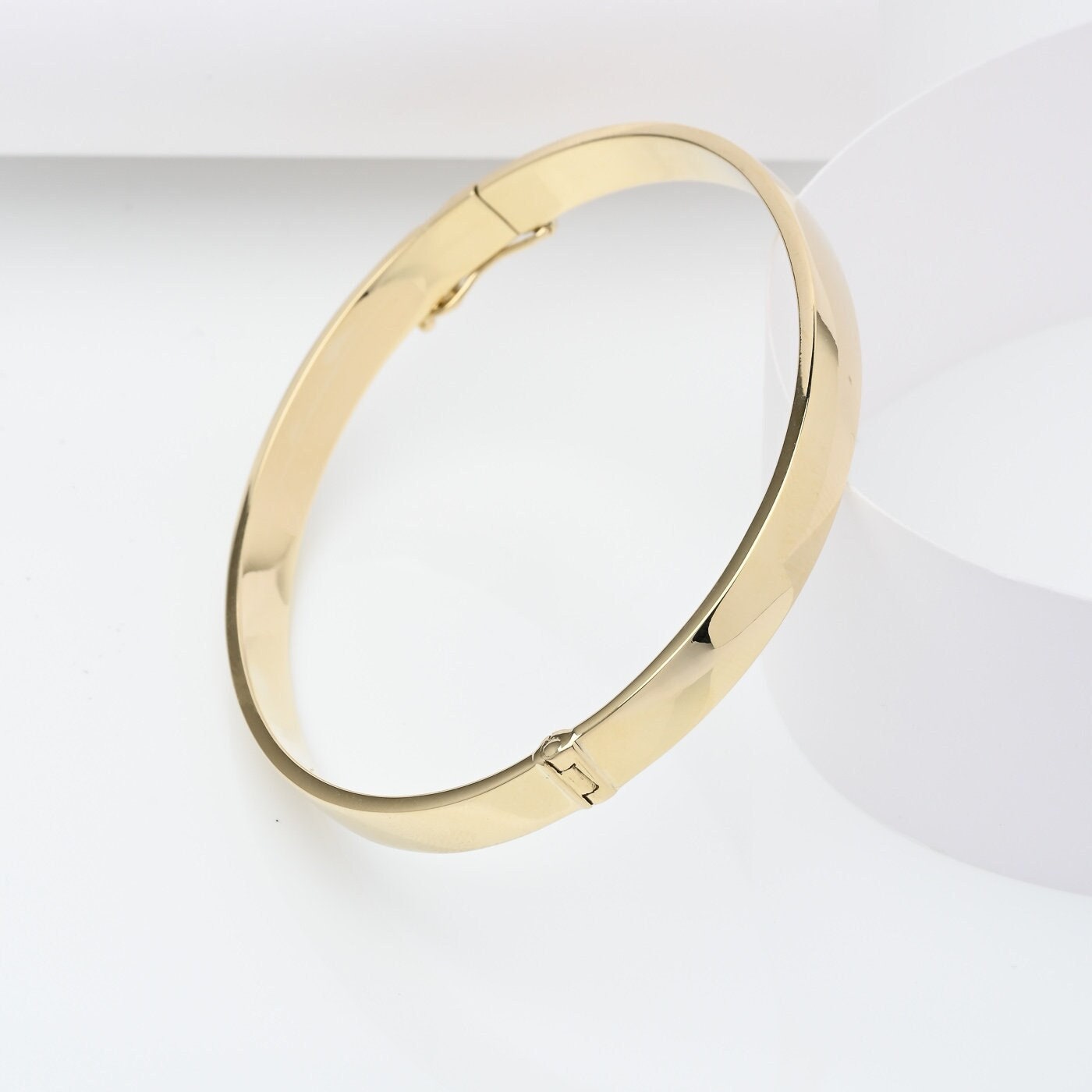 A 6.00mm hinged bangle bracelet crafted in 14k gold for women.