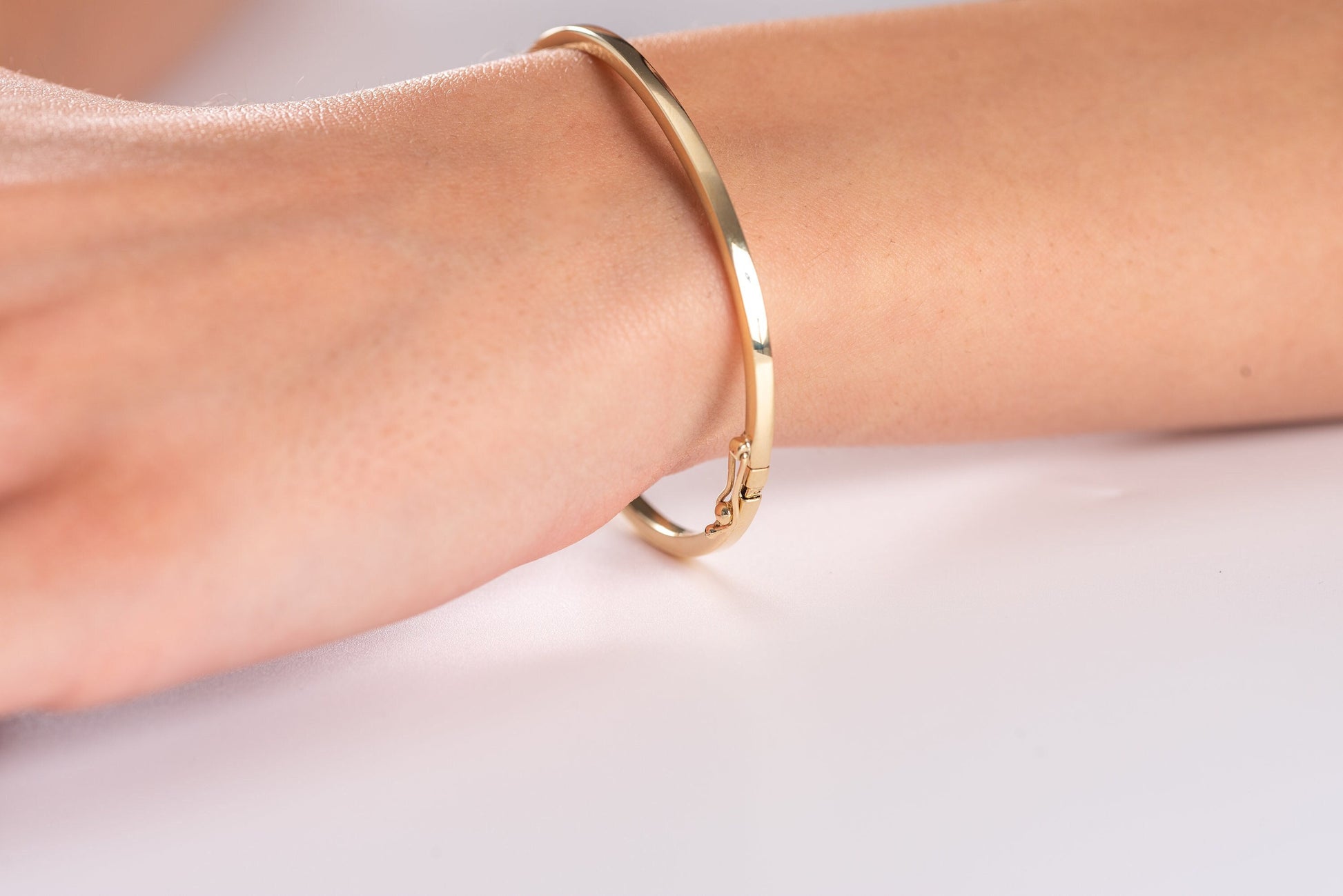 A 2.50mm bangle bracelet crafted in 14k gold, designed for women. 