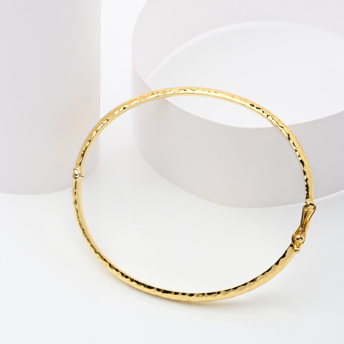 A 4.20mm hammered bangle bracelet in 14k gold, designed for women to adorn their wrist.