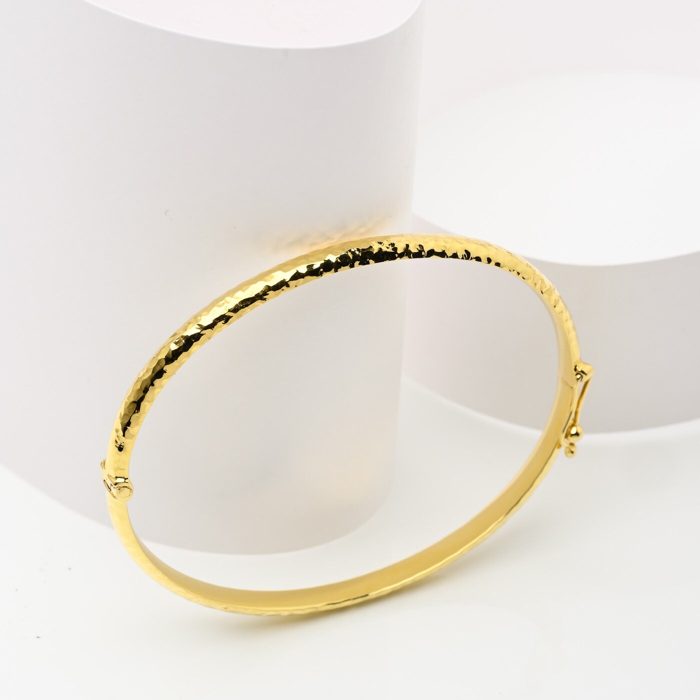 A 4.20mm hammered bangle bracelet in 14k gold, designed for women to adorn their wrist.