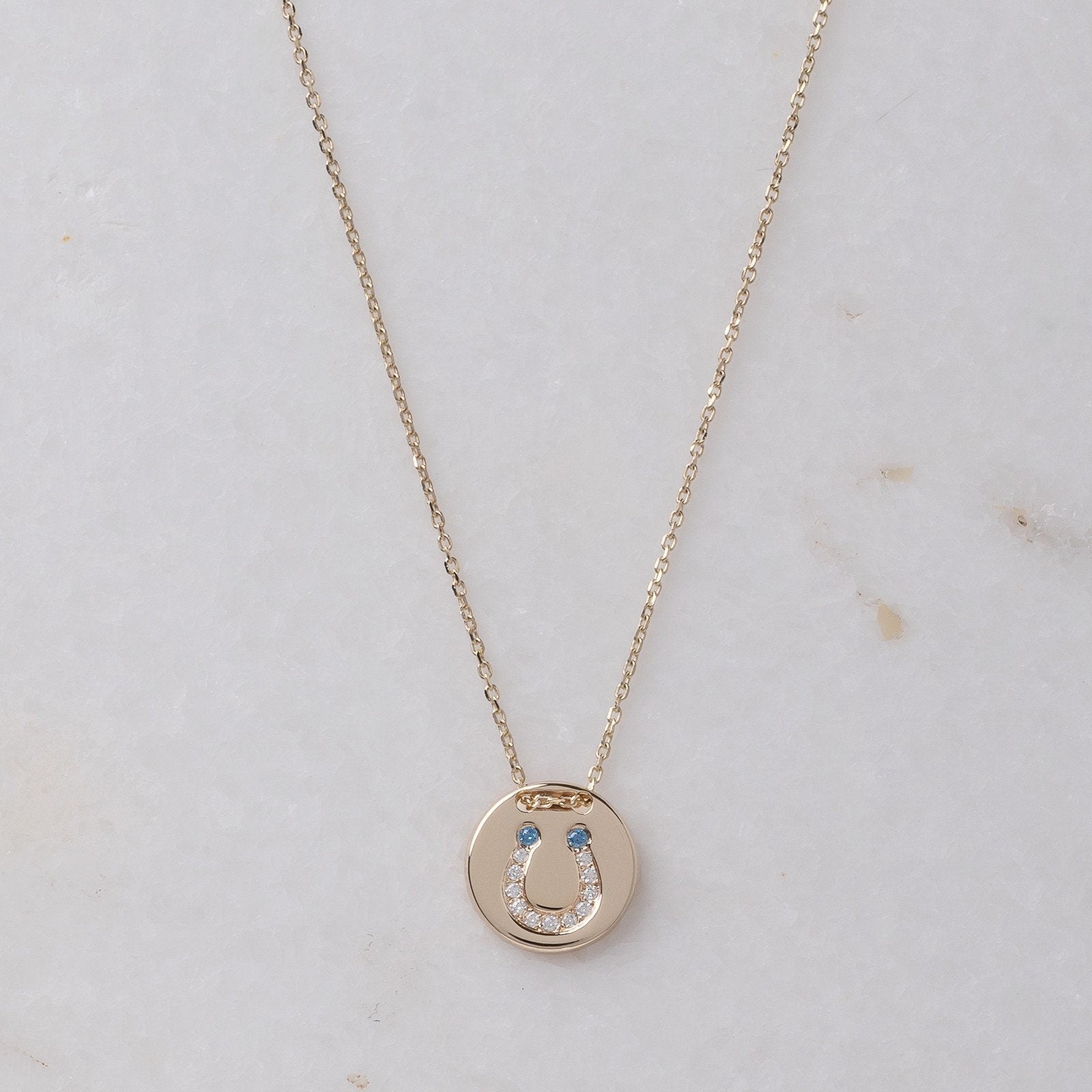 coin necklace in 14k gold with paved horseshoe