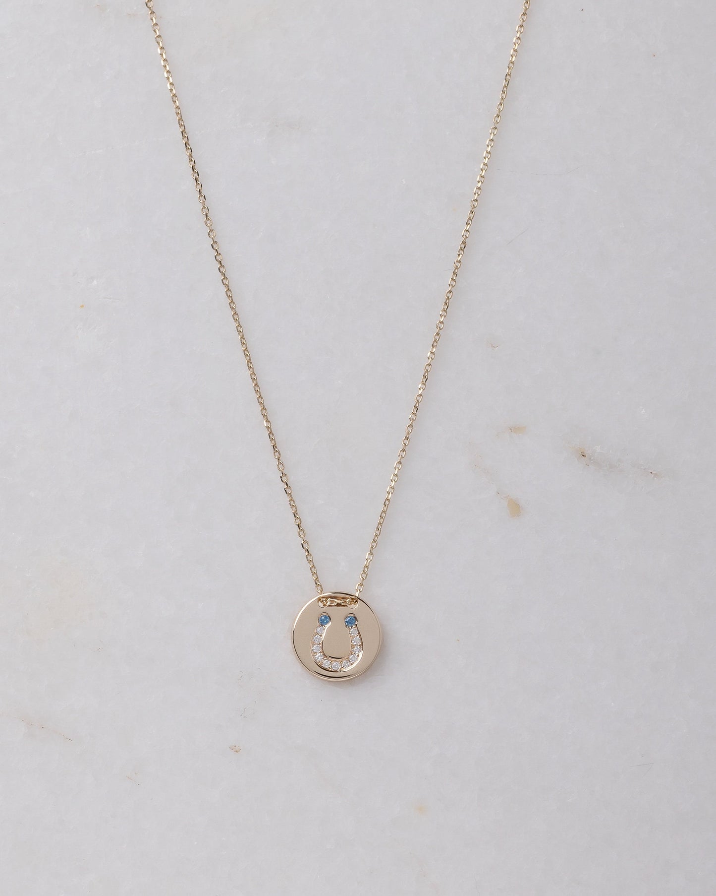 coin necklace in 14k gold with paved horseshoe